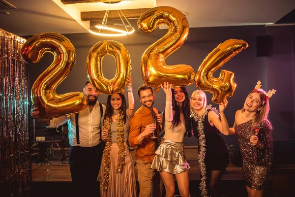 一群年轻人在夜总会庆祝新年 他们手里拿着金球数 — 图库照片