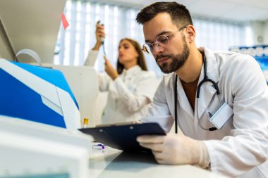 Laboratuvarda çalışan veterinerler. Veteriner doktorlar hayvan hastanesinde numune inceliyor..