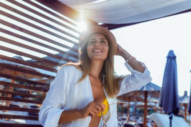 Kumsalda iskemlede dinlenen güzel genç bir kadın..