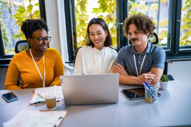 Uluslararası işçi grubu toplantı odasında takım çalışması tartışması yürütüyor..
