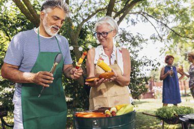 Yaşlı bir çift barbekü, sebze ve içecek yaparken aynı zamanda eğleniyor ve hatıralar yaratıyorlar..