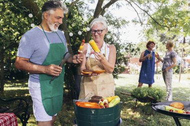 Yaşlı bir çift barbekü, sebze ve içecek yaparken aynı zamanda eğleniyor ve hatıralar yaratıyorlar..