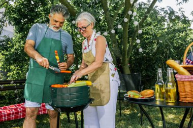 Yaşlı insanlar barbekü yapıyor, içki içiyor, hatıralar yaratıyor ve gülüyorlar..