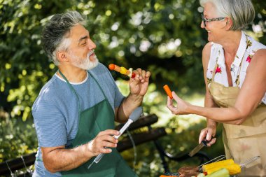 Yaşlı insanlar barbekü yapıyor, içki içiyor, hatıralar yaratıyor ve gülüyorlar..