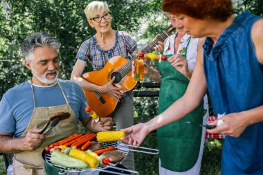 Yaşlı insanlar barbekü yapıyor, içki içiyor, hatıralar yaratıyor ve gülüyorlar..