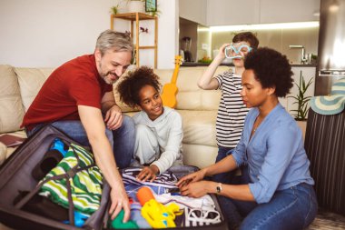 Happy family having great time and packing for summer holidays