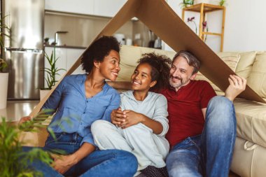 Portrait of a beautiful happy and smiling family just arrived in the new house to start a new journey together.