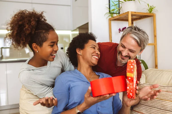 Father and daughter congratulate mother on holiday and give gift box