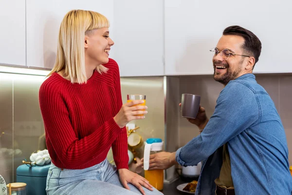 年轻男女们站在厨房里聊天 快乐的妻子和丈夫 厨房里站着一杯咖啡和果汁 — 图库照片