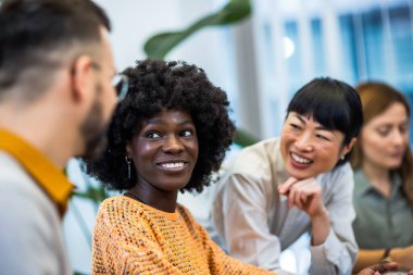 Dizüstü bilgisayarın başında duran çok ırklı meslektaşlar. Önemli iş bitiriliyor