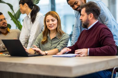 Dizüstü bilgisayarın başında duran çok ırklı meslektaşlar. Önemli iş bitiriliyor