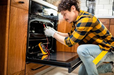 Sobayı tamir etmek için çoklu metre kullanan Latin bir adam..