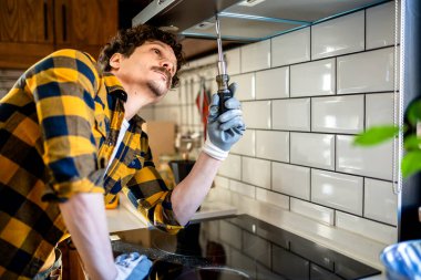 Latin adam mutfakta aspiratör tamir ediyor..