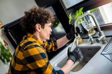 Latin adam mutfakta lavabo tamir ediyor..