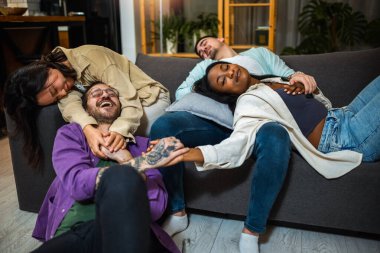 Partiden sonra sarhoş ve akşamdan kalma bir şekilde oturma odasındaki kanepede uyuyan çok ırklı arkadaşlar..