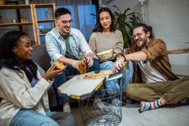 Çok ırklı arkadaş grubu pizza partisi veriyor..