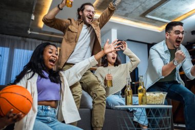 Basketbol maçı izleyen, bira içen ve tezahürat yapan çok ırklı bir arkadaş grubu..