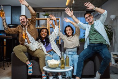 Oyun izleyen, tezahürat yapan ve bira içen çok ırklı bir arkadaş grubu..