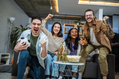 Futbol maçı izleyen, tezahürat yapan ve bira içen çok ırklı arkadaş grubu..