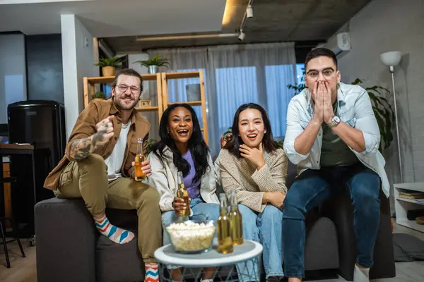 Oyun izleyen, tezahürat yapan ve bira içen çok ırklı bir arkadaş grubu..