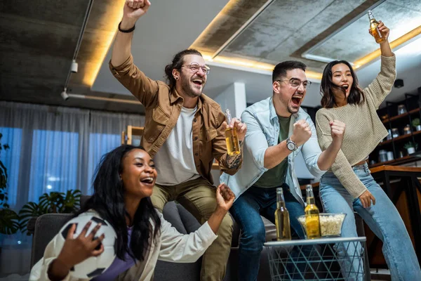 Futbol maçı izleyen, tezahürat yapan ve bira içen çok ırklı arkadaş grubu..