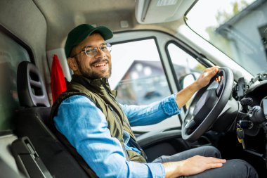 Çekici servisinde çalışan ve kamyonunu süren yakışıklı bir genç..