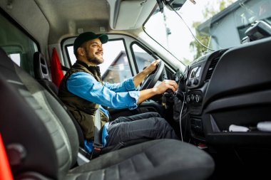 Çekici servisinde çalışan ve kamyonunu süren yakışıklı bir genç..