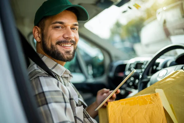 Genç yakışıklı teslimatçı teslimatlarını hazırlıyor, tableti arıyor..
