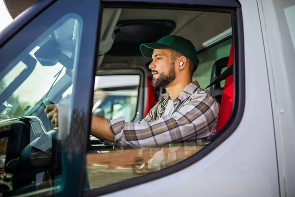 トラックを運転しながらエラフォンを持っている若いトラック運転手 — ストック写真