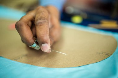 Genç Afrikalı Amerikalı terzi iplikle dikiş dikiyor..