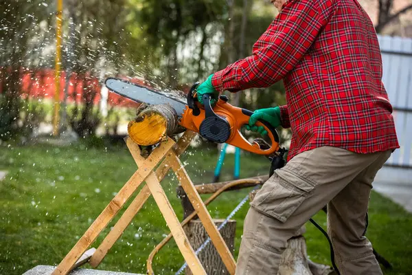 Man cutting wood with saw, dust and movements. Chainsaw.