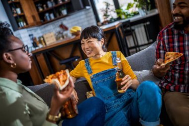 Evde bira içip pizza yiyen çok ırklı bir arkadaş grubu..