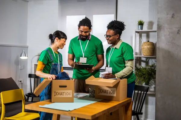 Activistas Sonrientes Colocando Ropa Segunda Mano Cajas Cartón Para Donación —  Fotos de Stock