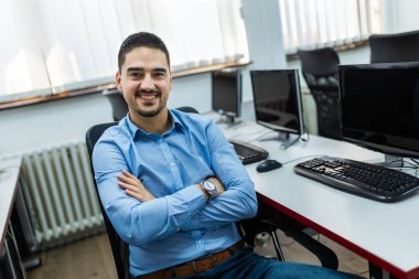 Bilgisayar laboratuvarında masaüstü bilgisayarı kullanan erkek öğrenci.