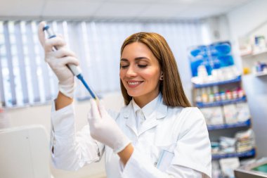 Laboratuvarda çalışan bir kadın veteriner. Veteriner doktor hayvan hastanesinde numune inceliyor. Üniforma giyiyor..