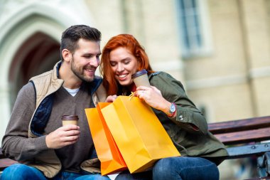 Mutlu çift alışveriş sonra şehir gülümseyen ve holding kredi kartı alışveriş torbaları ile portresi