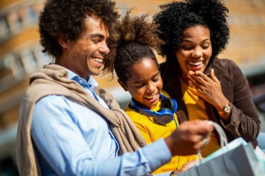 Mutlu genç melez çift kızlarıyla alışverişte vakit geçiriyor..