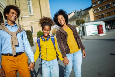 Genç Afrikalı Amerikalı aileler çocuklarını okula götürüyorlar.