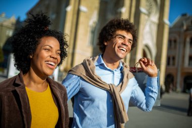 Güzel, genç bir çift alışveriş torbaları taşıyor ve birlikte eğleniyorlar..
