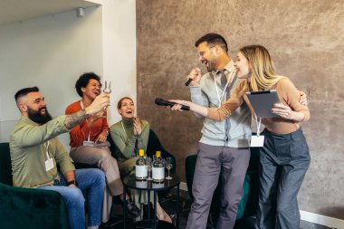 Takım kurma semineri sırasında takım çalışması yapan iş adamları karaoke söyleyip içiyorlar..