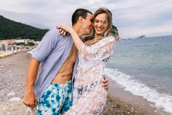 幸せな若いカップル笑いとビーチで抱擁 — ストック写真