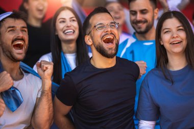 Futbol ve futbol taraftarları maçta takımları için tezahürat yapıyorlar.