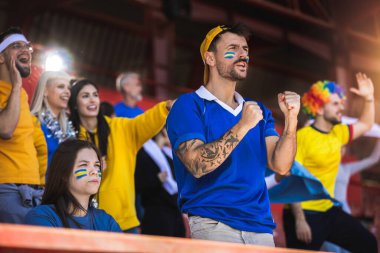 Futbol ve futbol taraftarları maçta takımları için tezahürat yapıyorlar.