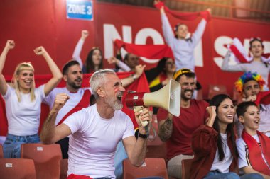 Futbol ve futbol taraftarları maçta takımları için tezahürat yapıyorlar. Amigo kız megafon kullanıyor.