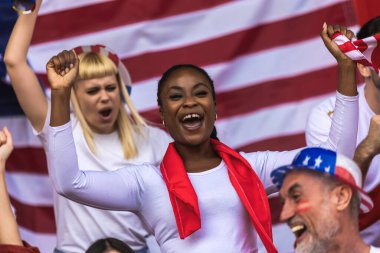 Amerikan futbolu ve futbol taraftarları stadyumda bayraklar ve diğer ekipmanlarla tezahürat yapıyorlar