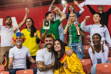 Alman futbol / futbol taraftarları stadyumda bayraklar ve diğer ekipmanlarla tezahürat yapıyorlar