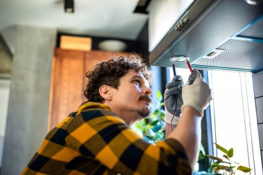 Latin adam mutfakta aspiratör tamir ediyor..