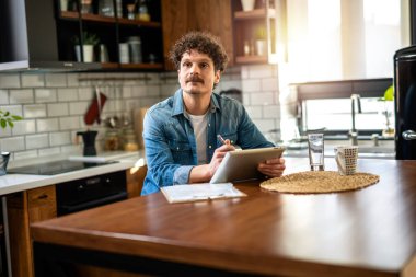 Mutfaktaki Latin Adam Evde Dijital Tablet Kullanarak Çalışıyor