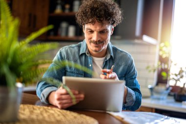 Mutfaktaki Latin Adam Evde Dijital Tablet Kullanarak Çalışıyor