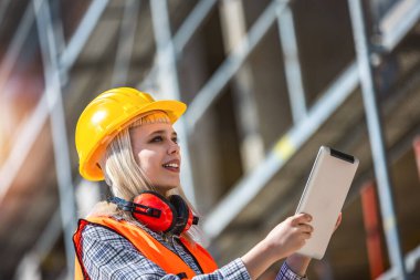 Tablet kullanan mimar kadın inşaat alanında mutlu ve sanayi, planlama ve teftiş.